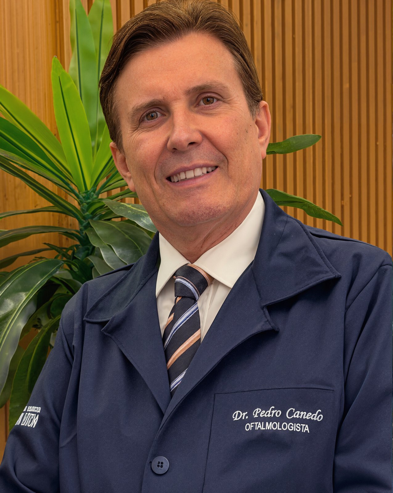 Dr. Pedro Canedo, de jaleco azul-marinho, na Clínica de Olhos Santa Luzia, em Anápolis